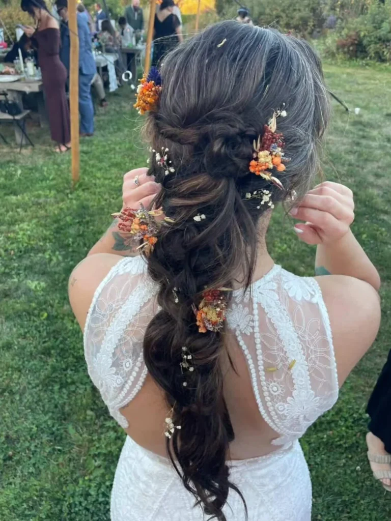 Dark brunette autumn bridal braid decorated with orange, cream and burgundy dried flowers.