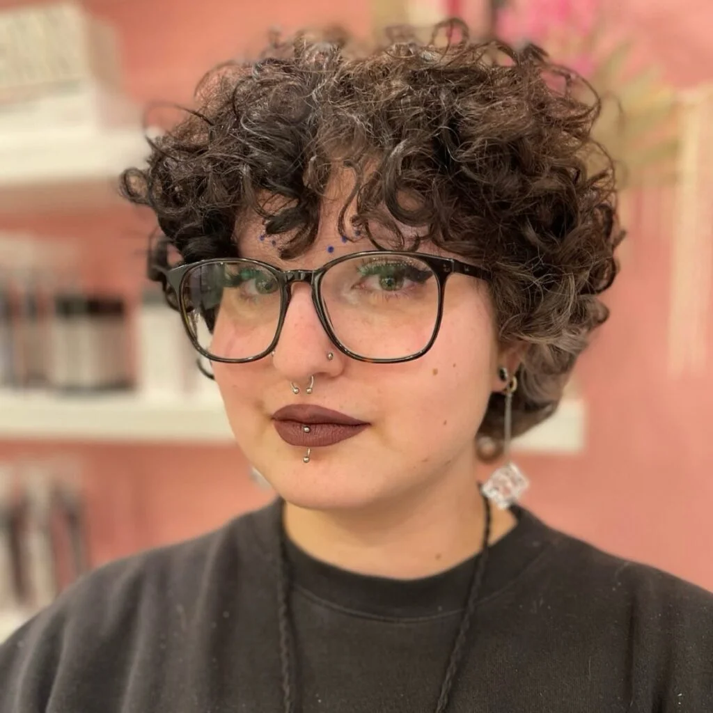 Curly pixie bob with glasses and short bangs