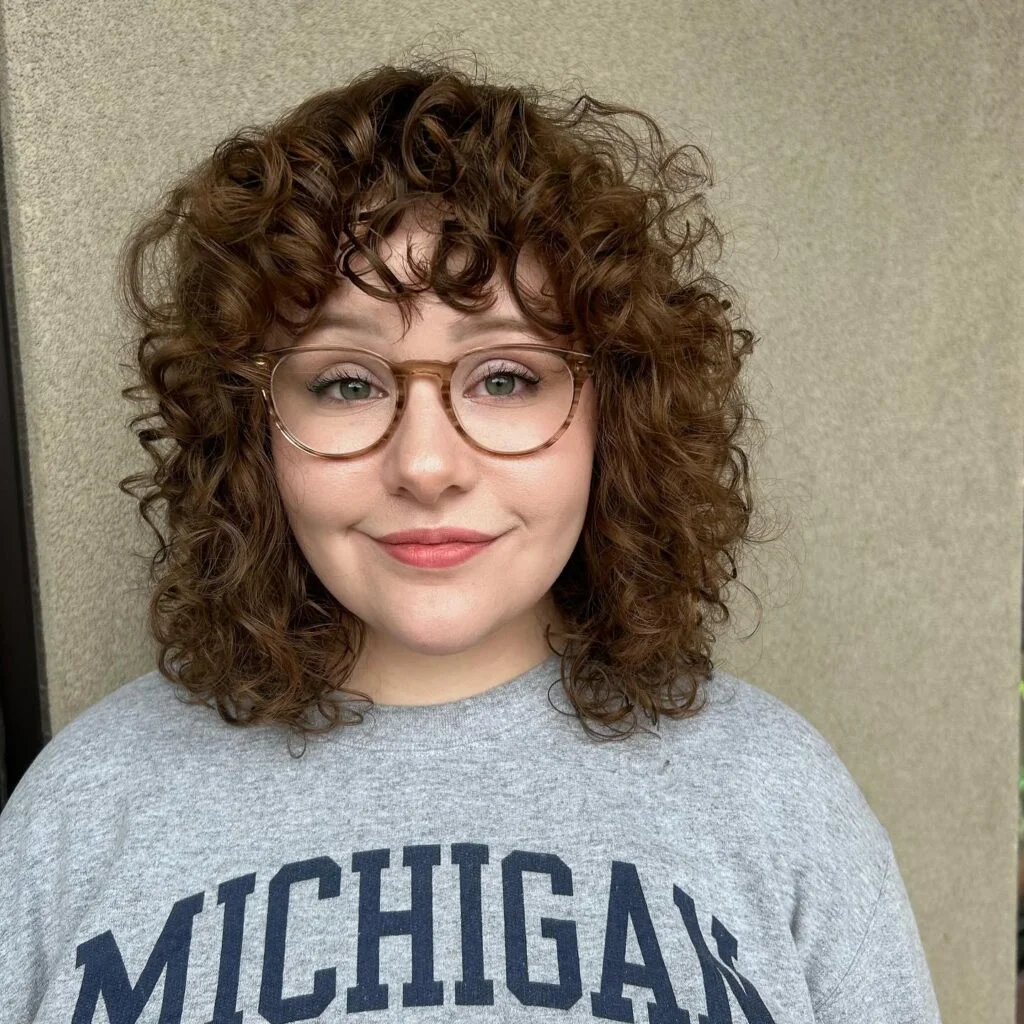 Rounded curly bob with short curly fringe and glasses