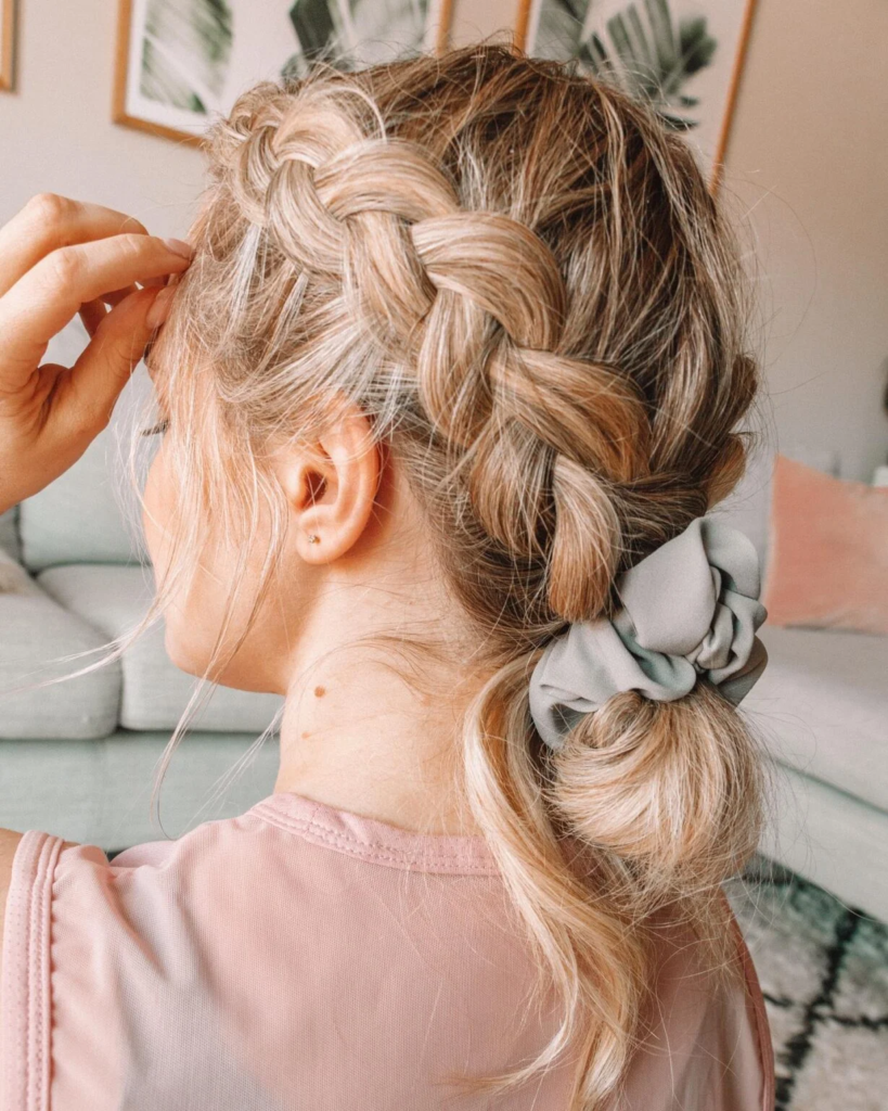 Loose blonde Dutch braid with a scrunchie ponytail