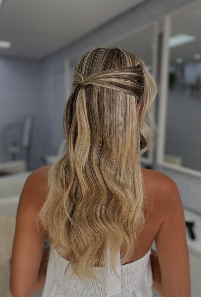 Wrapped half-up knot with long highlighted blonde waves