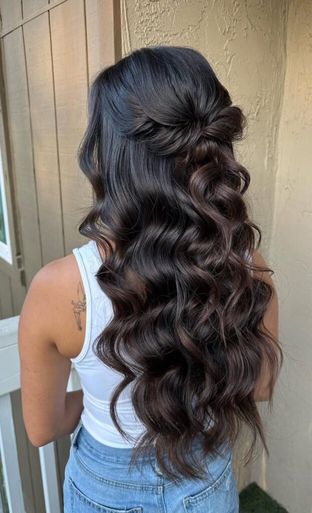 Side rosette half-up hairstyle with glossy dark brown curls