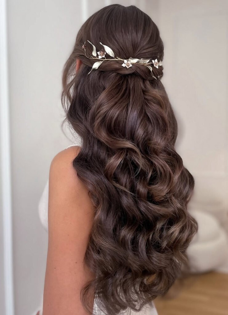 Floral hair vine over a twisted half-up style with long brunette curls