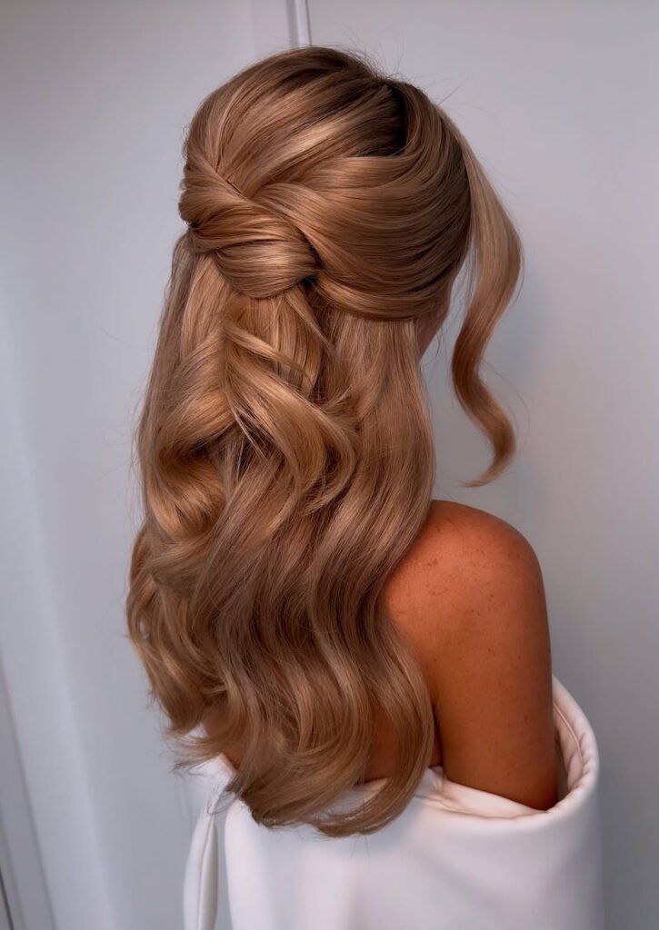 Sculpted half-up knot with long copper brushed waves and a face-framing curl