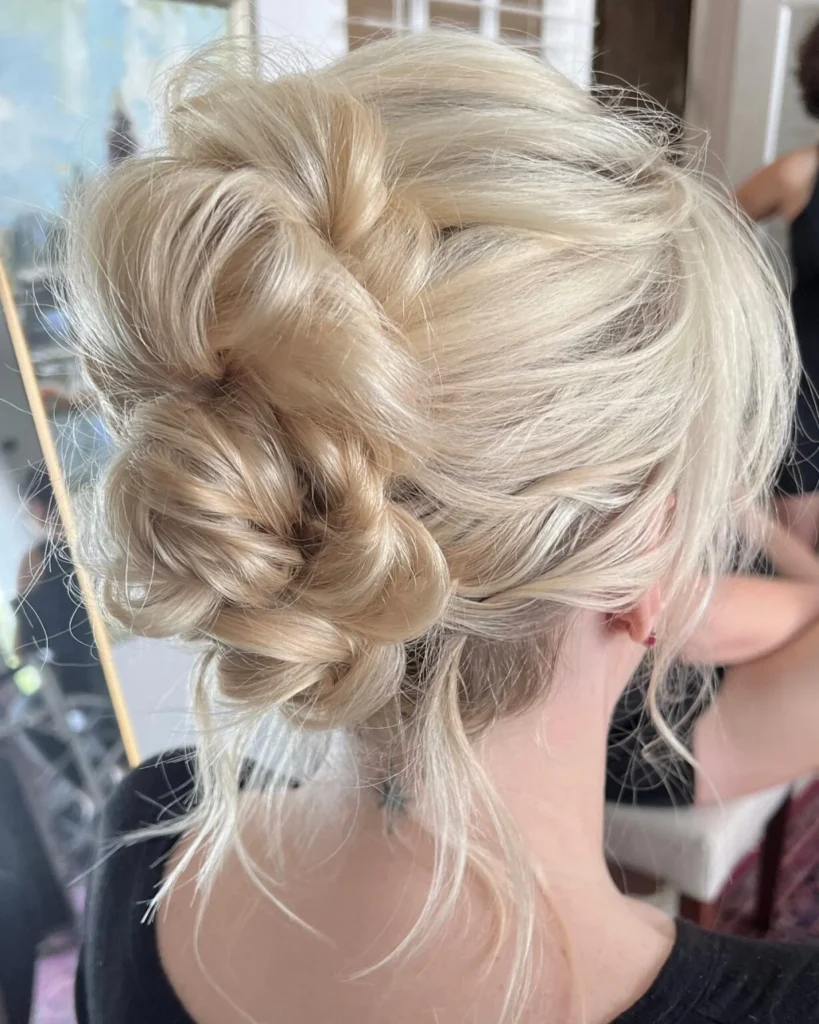 Textured low twisted blonde updo with loose face-framing strands