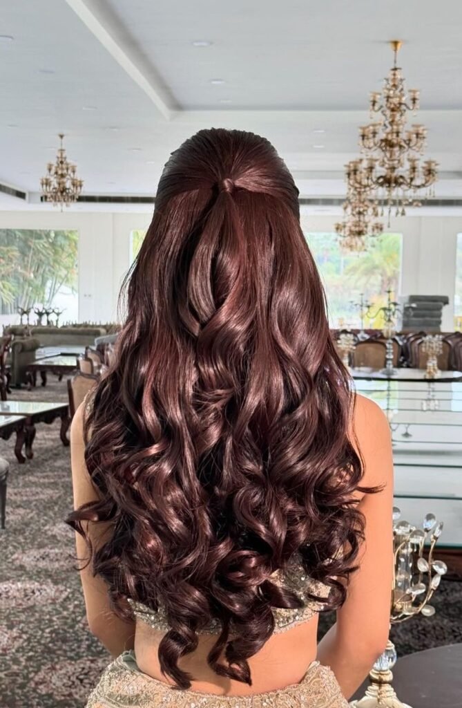 Sleek half-up ponytail with glossy auburn curls