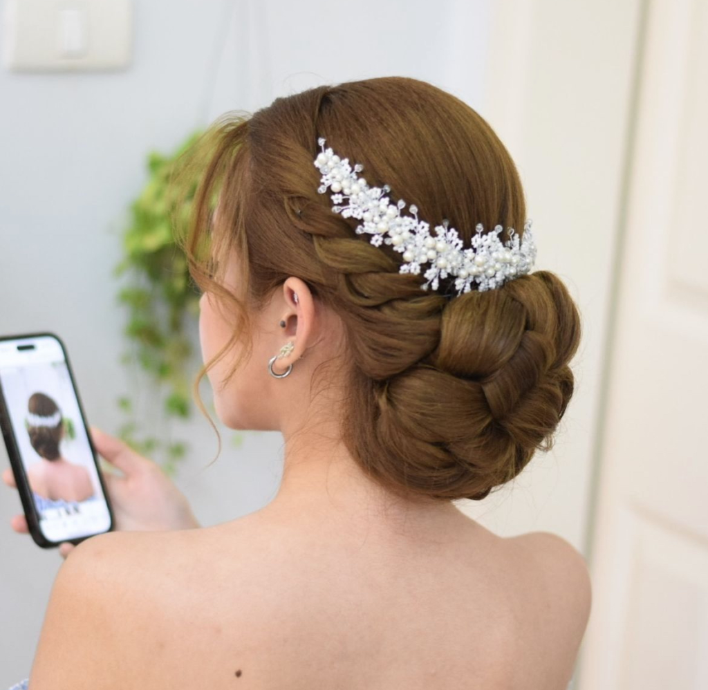Braided auburn low bun with a pearl floral crown vine across the back