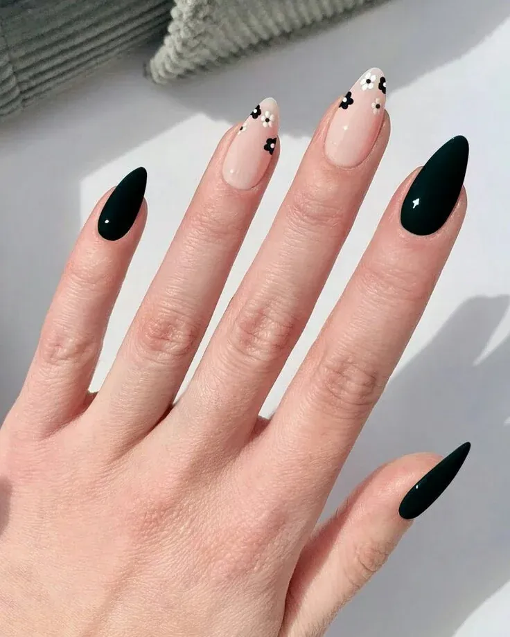 Black almond nails with nude and white floral accent nails