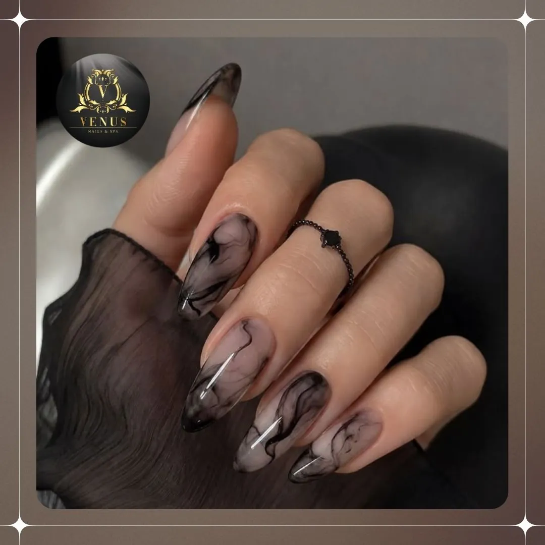 Sheer nude almond nails with smoky black swirls