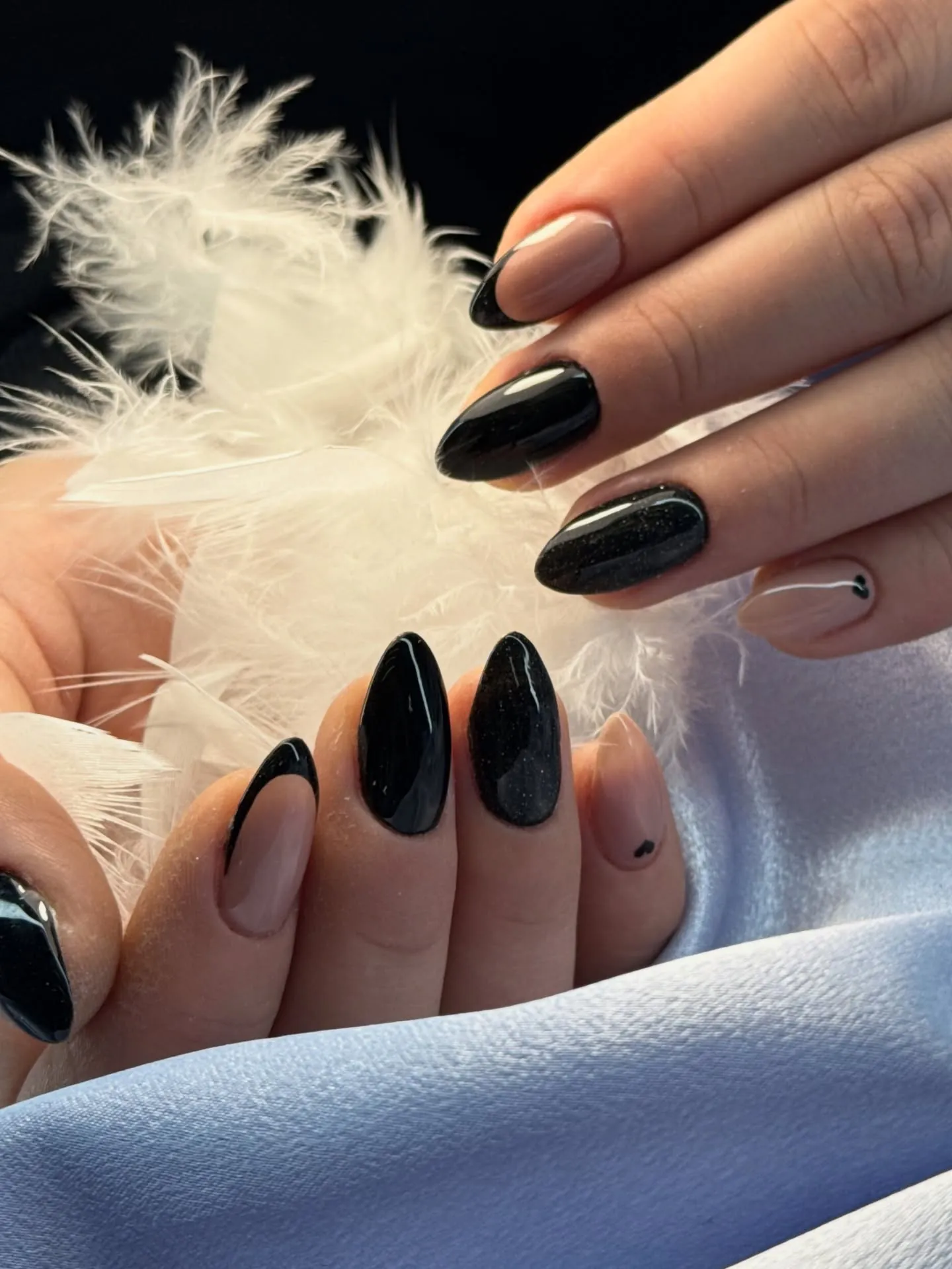 Glossy black almond nails paired with nude French accents