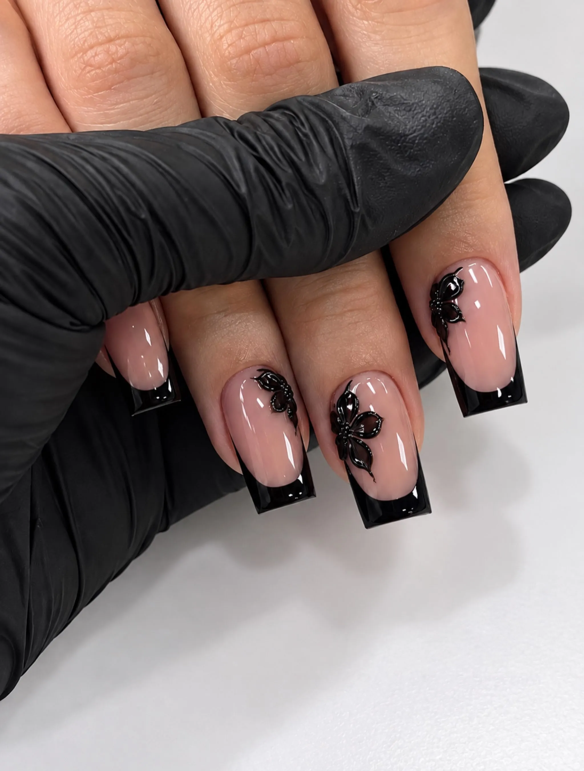 Nude square nails with black French tips and dark botanical artwork