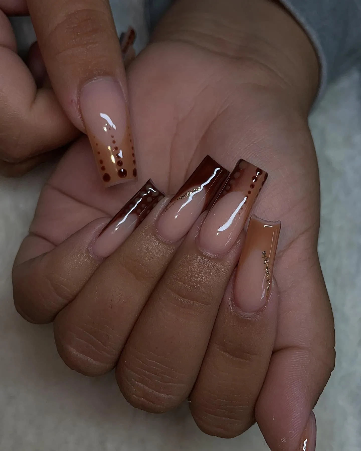 Long square pink nude nails with brown French tips and small brown dots