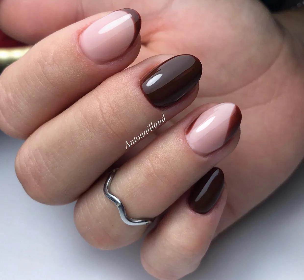 Short almond nails mixing solid dark brown with pink bases and brown tips