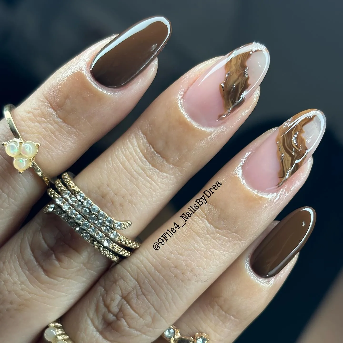 Almond nails with brown solids, nude marble accents, white outlines and silver flecks