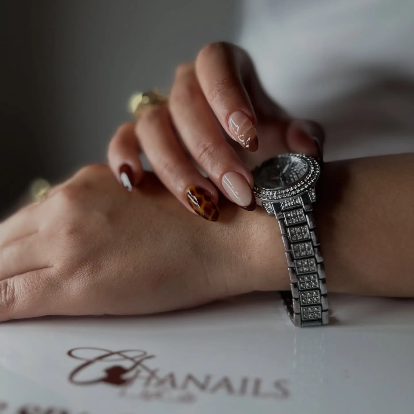 Almond nails with brown French tips, brown marbling and fine pale accent lines