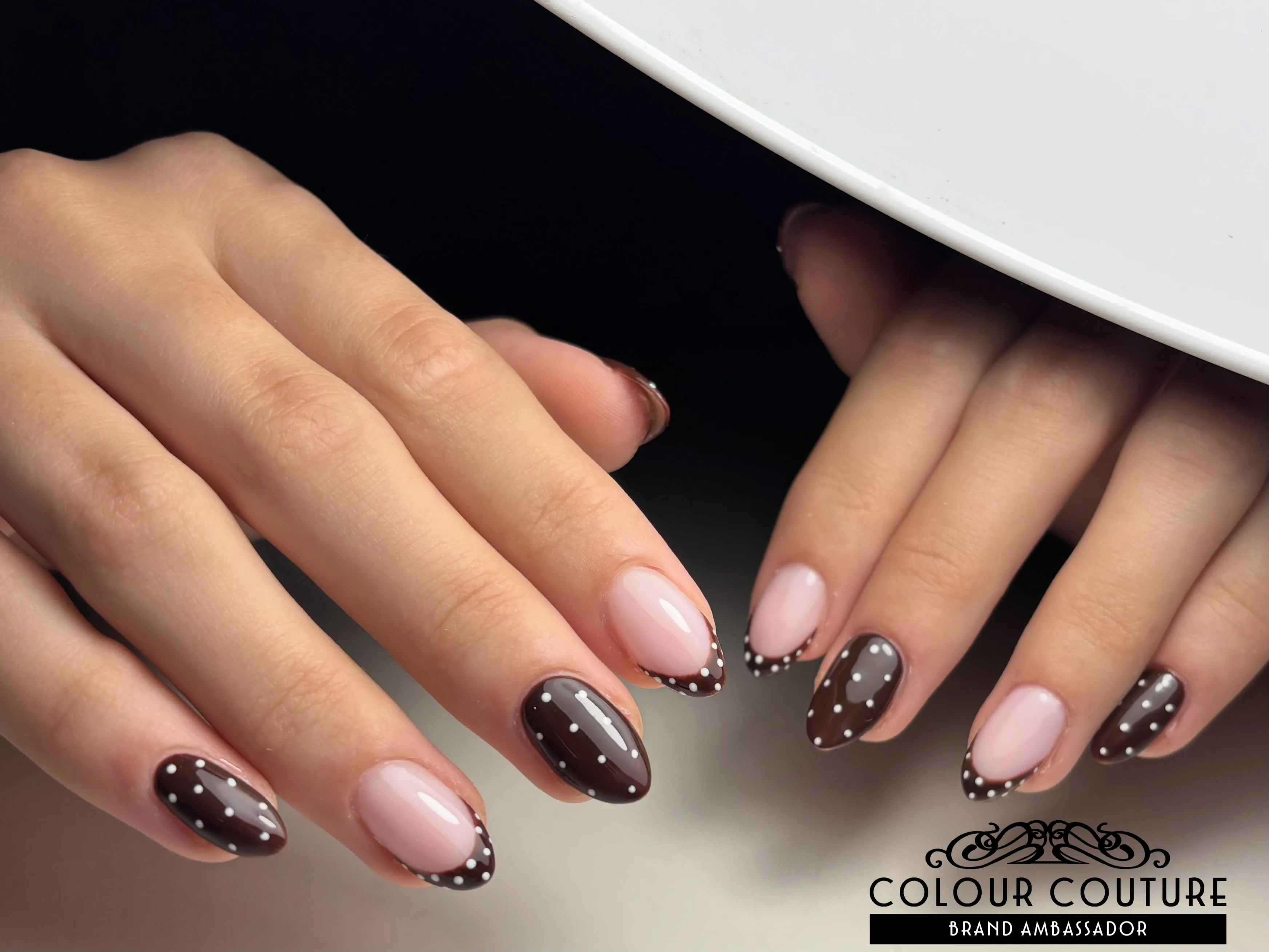 Glossy dark brown dotted almond nails alternating with pink dotted French accents