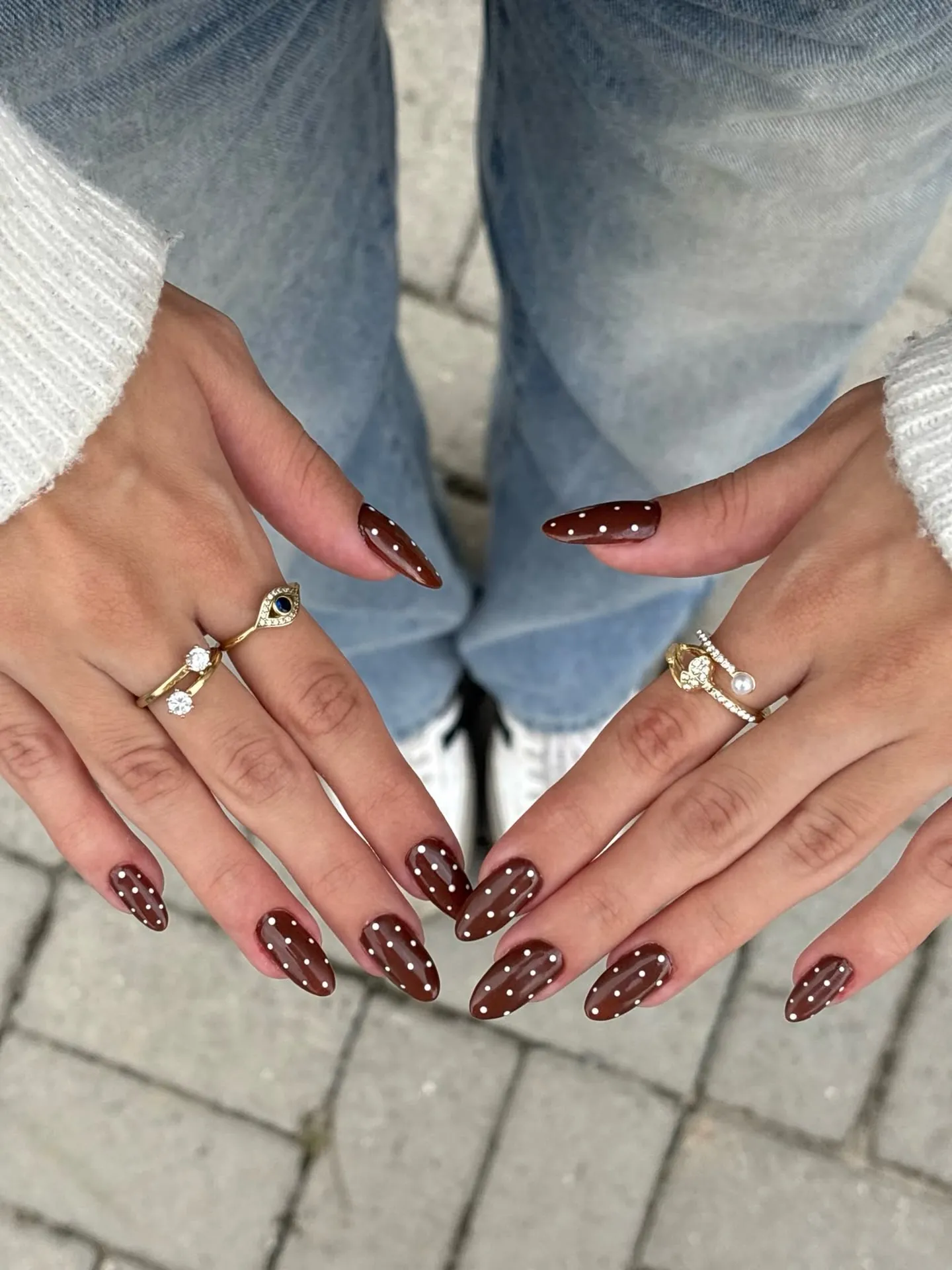 Long almond brown nails with small pale polka dots