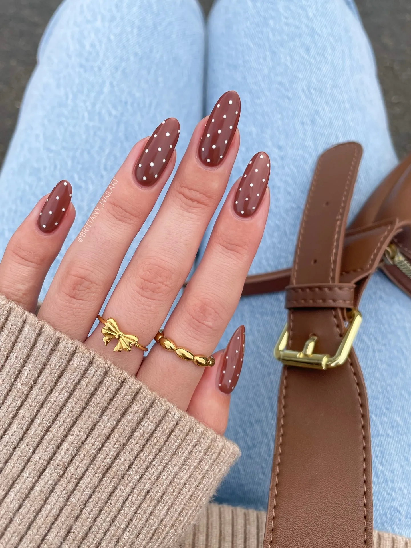 Warm brown almond nails with small pale polka dots