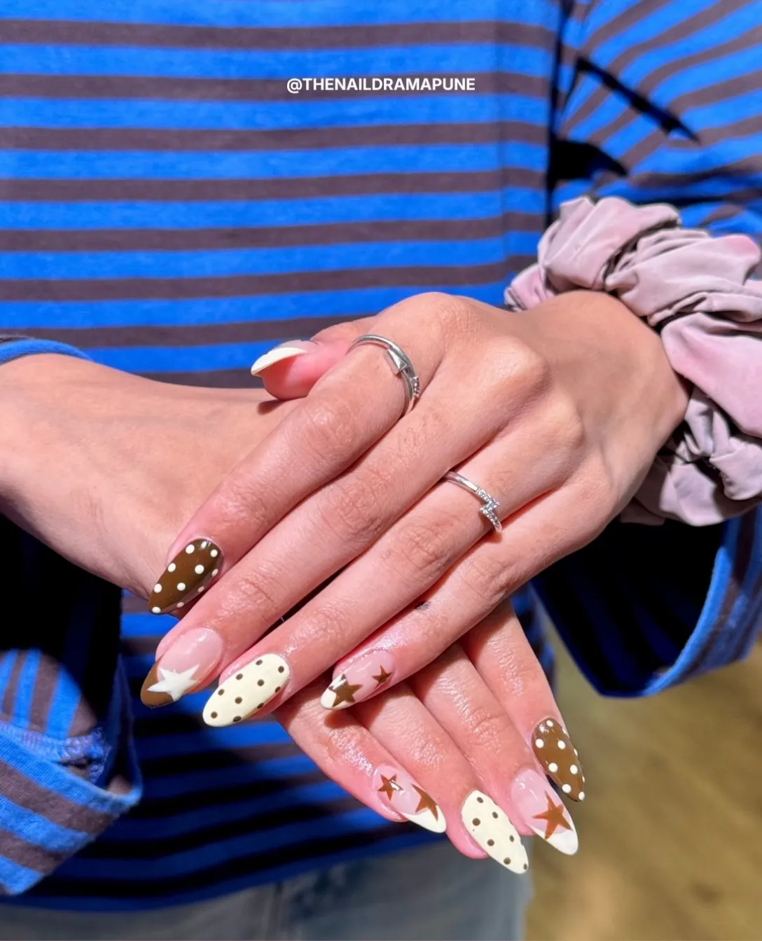 Mixed brown and cream nail art with polka dots, stars and pale pink accents