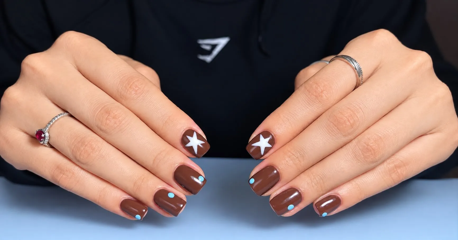 Short brown oval nails with bright white four-point stars