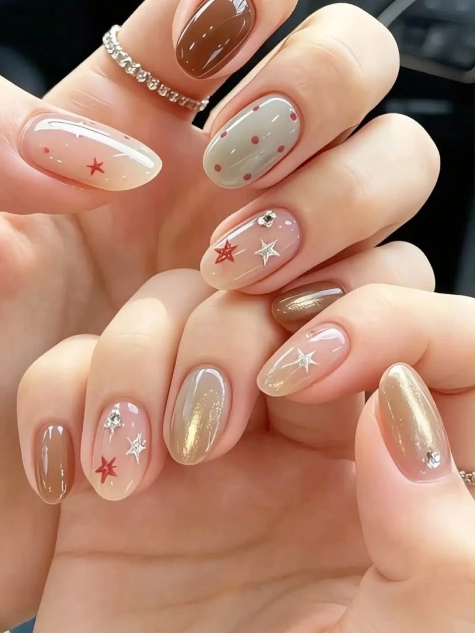 Nude and bronze nails with tiny brown stars, gold accents and dots