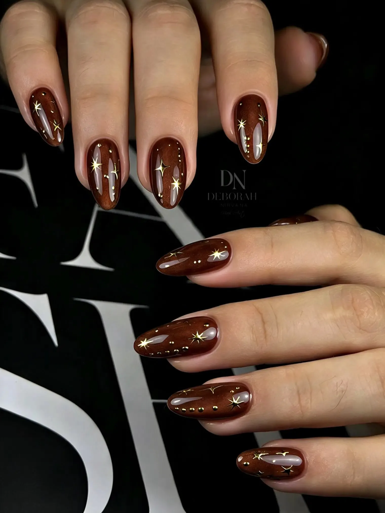 Long glossy chocolate nails with slender vertical metallic embellishments