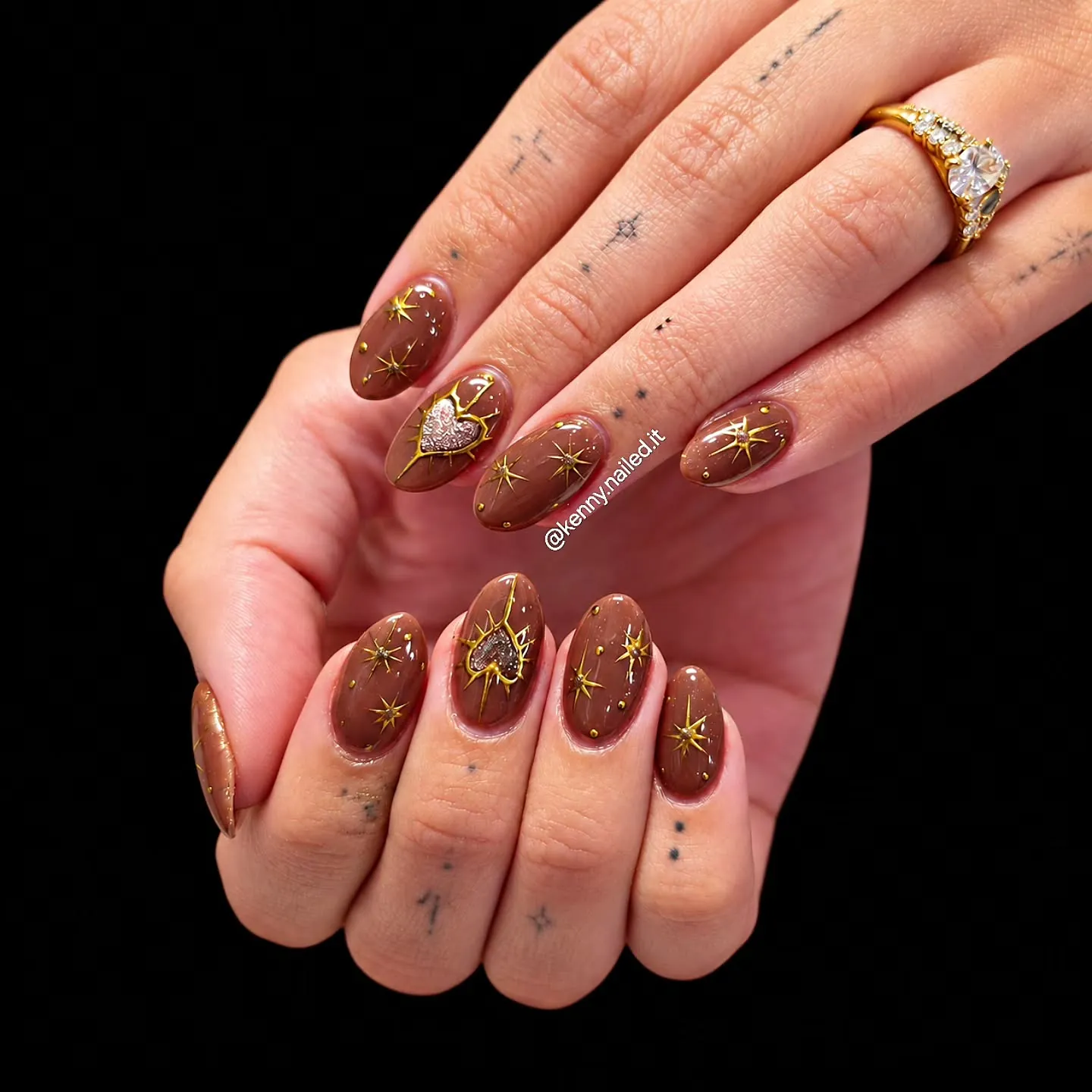 Long chestnut brown nails with fine gold sunburst and star details