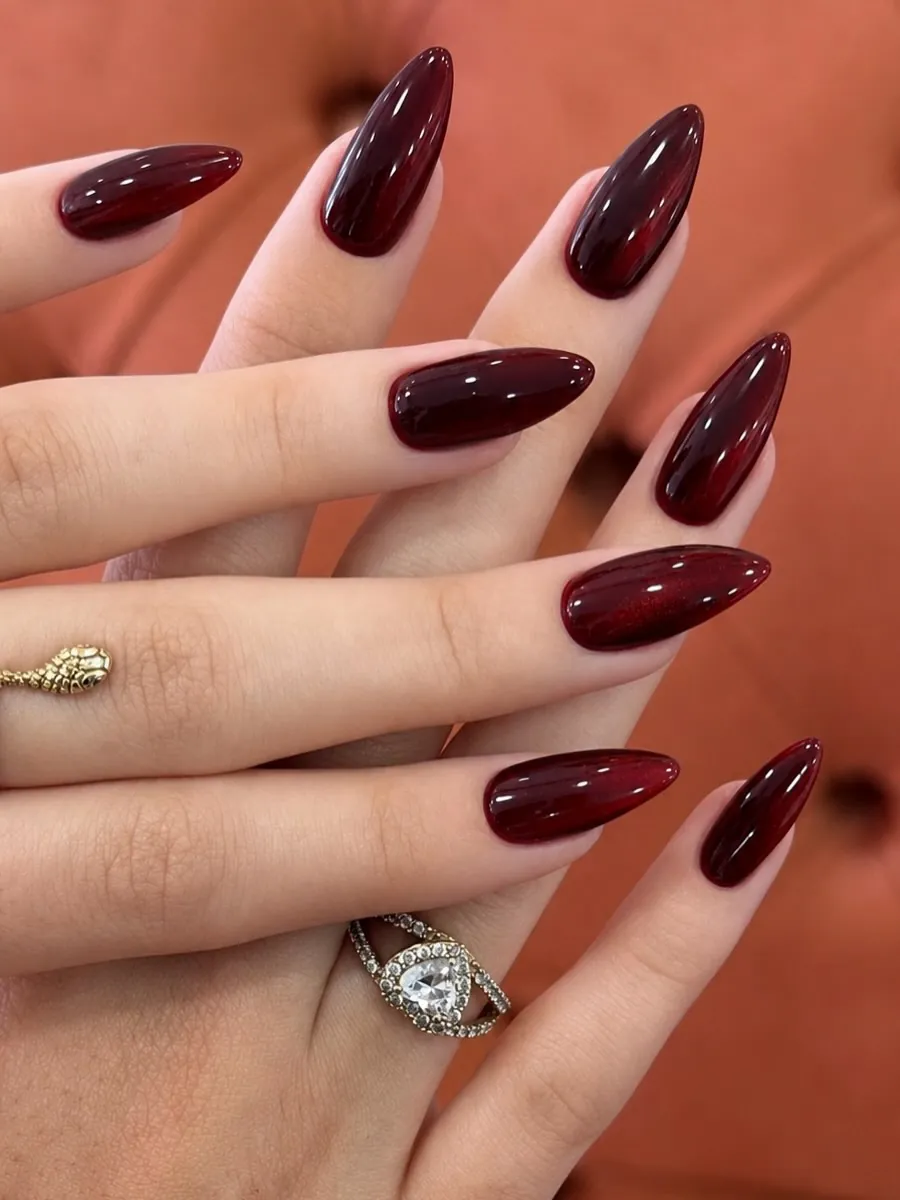 Long pointed almond nails with deep wine polish