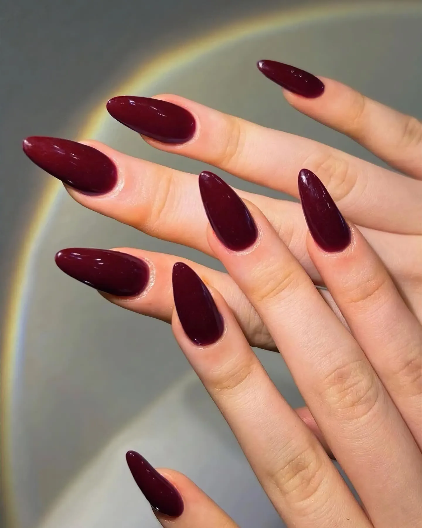 Long almond nails with a rich red burgundy finish