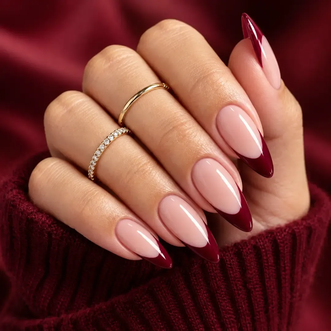 Nude pink almond nails with broad deep burgundy French tips