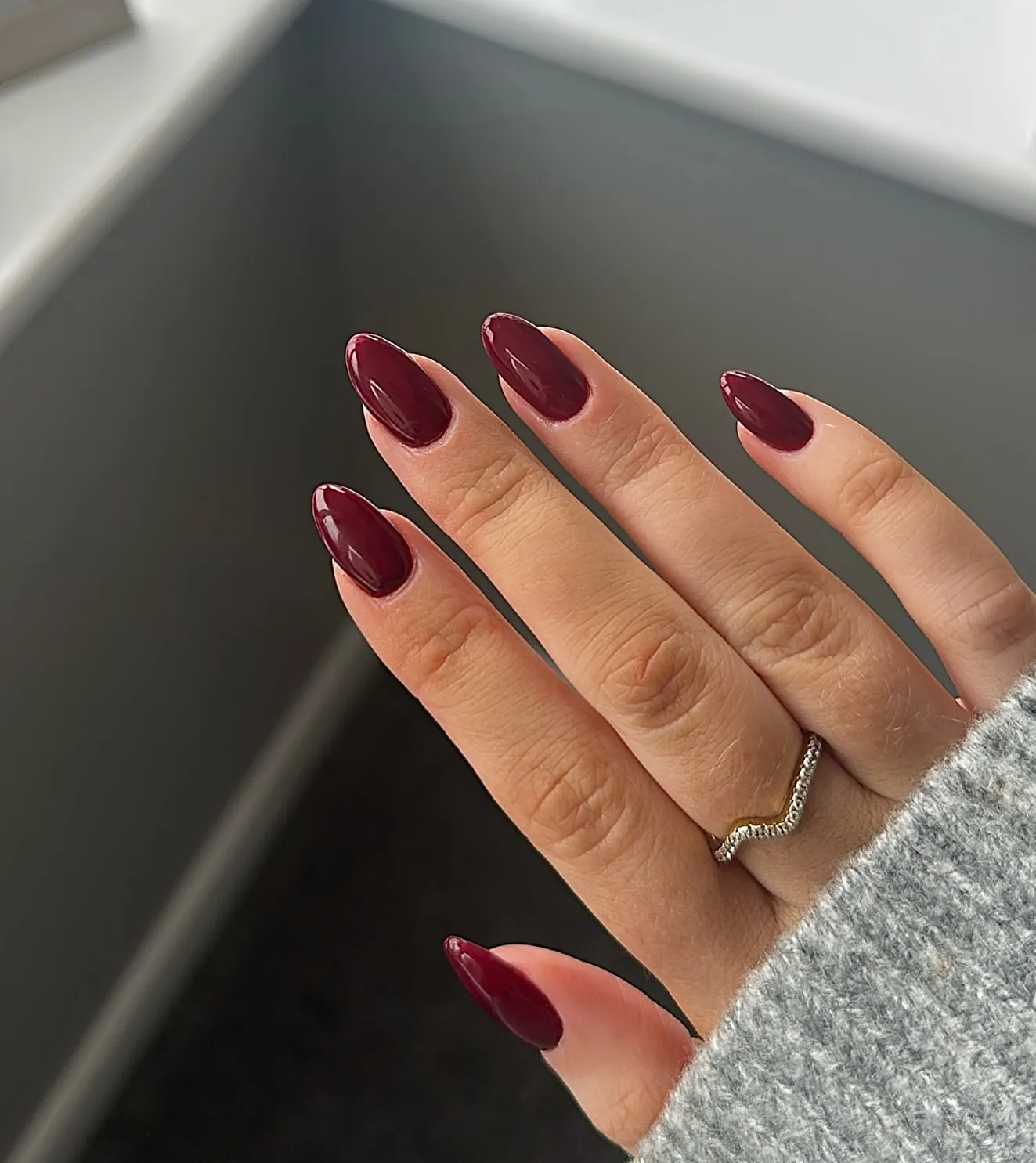 Medium almond nails in a warm burgundy red shade
