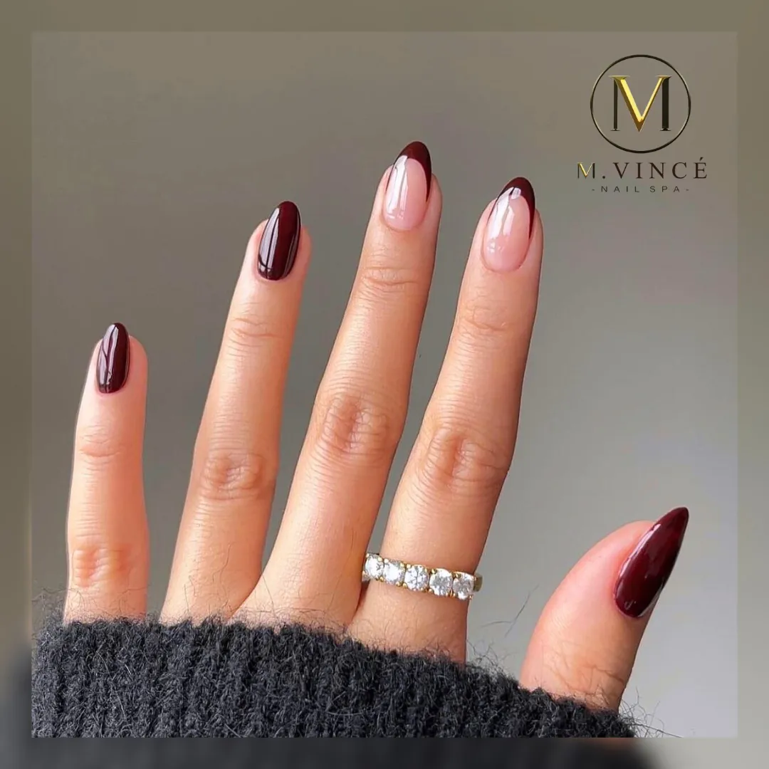 Almond nails mixing solid burgundy with pink burgundy French accents