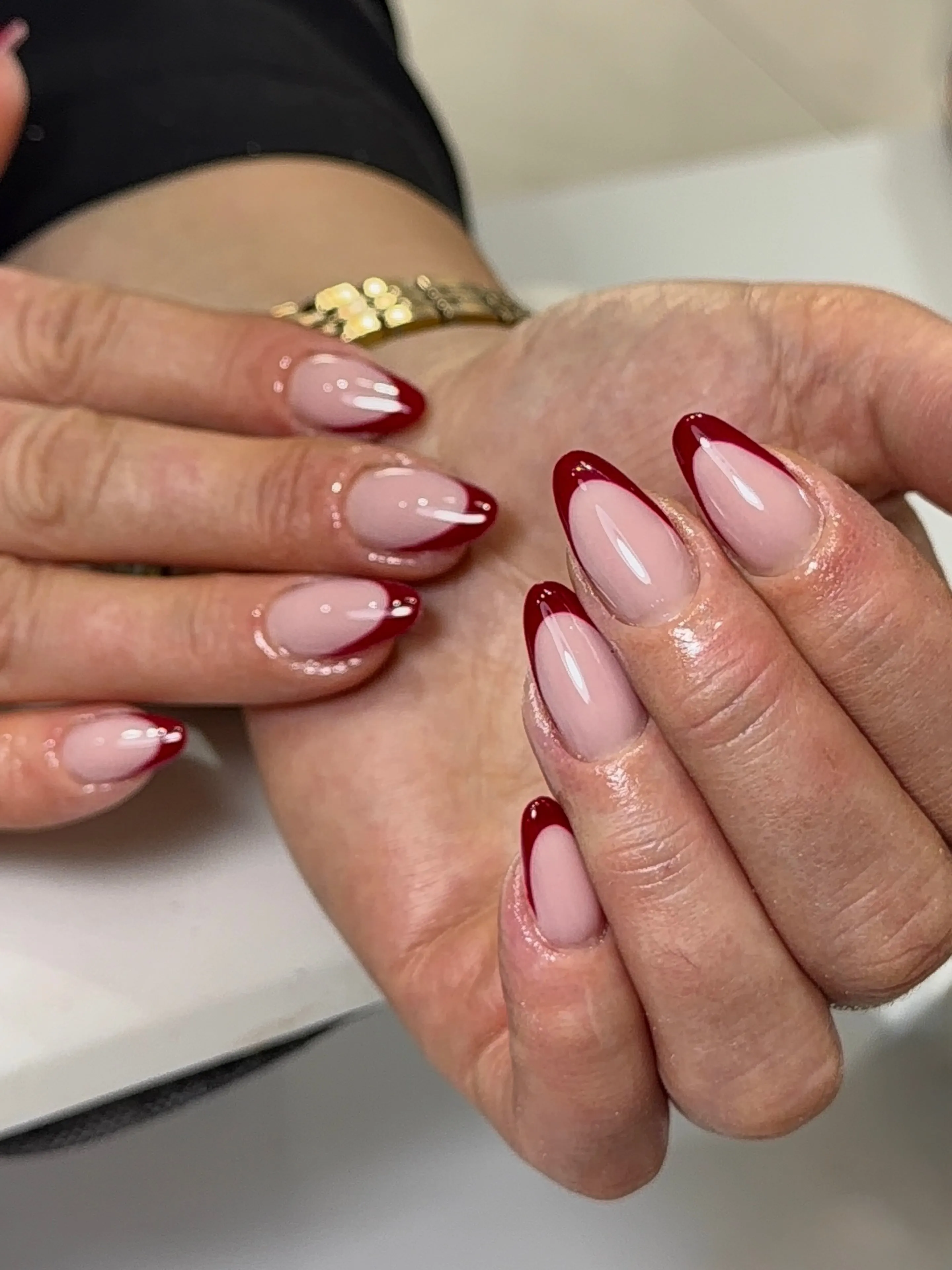 Pink almond nails with burgundy tips and tiny white edge accents