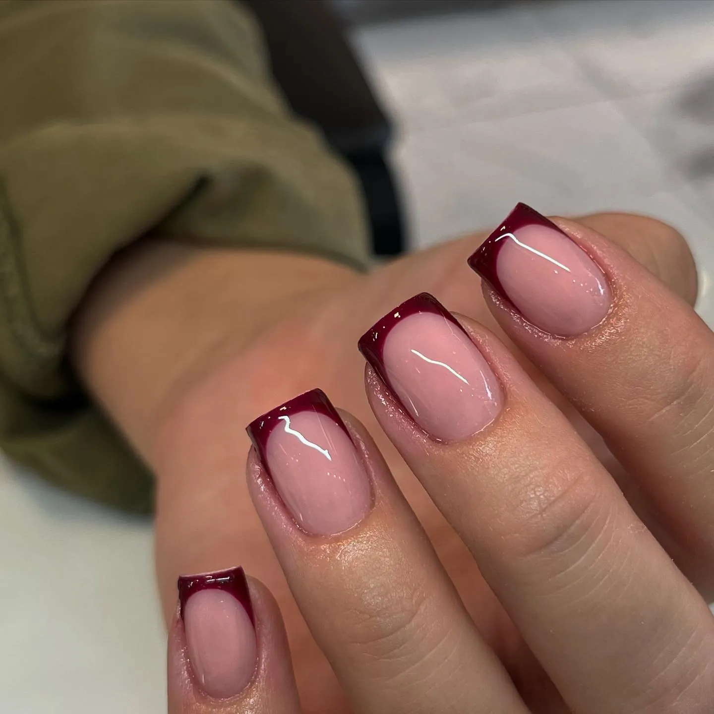 Short square nails with pink bases and dark burgundy tips