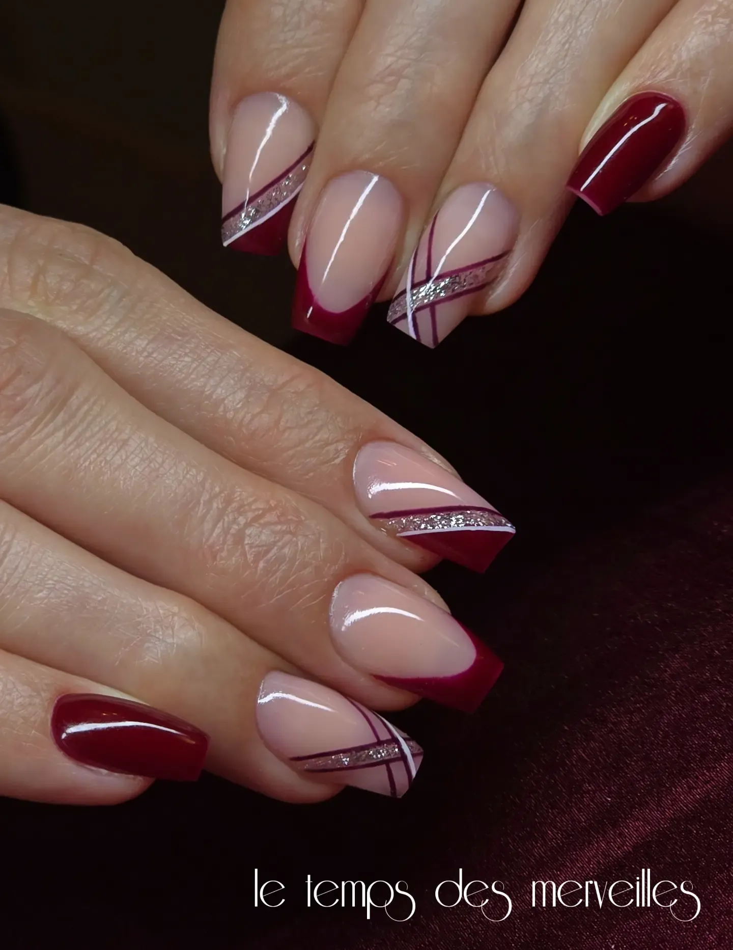Burgundy French and solid nails with diagonal fine lines and glitter accents