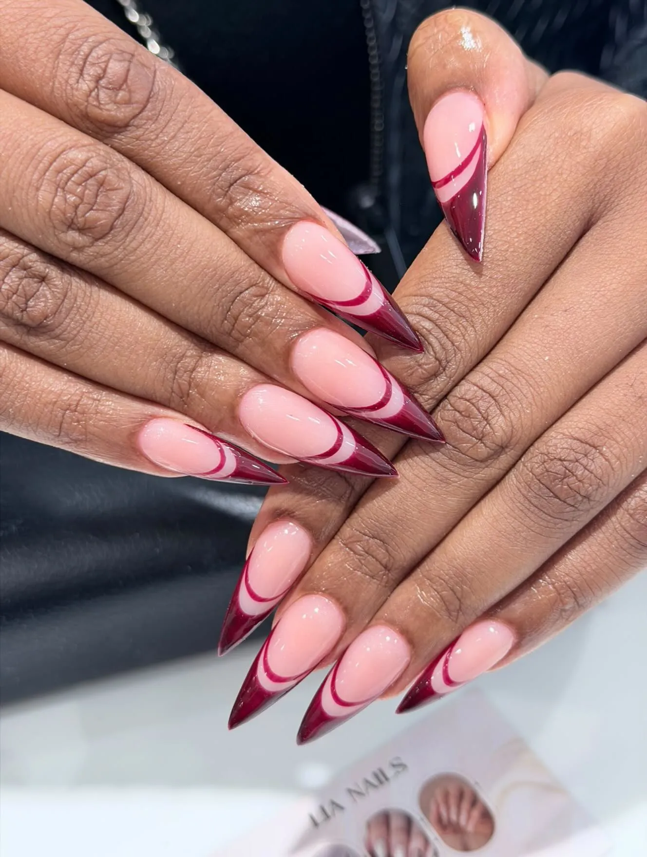 Long pointed nails with layered pink and burgundy curved French tips