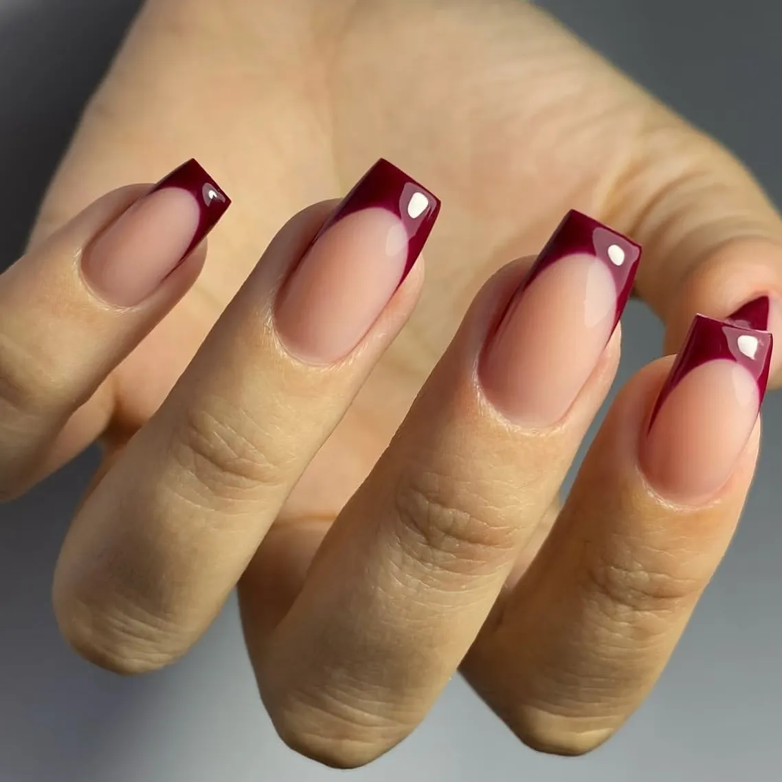 Square burgundy French tips with small bright corner studs