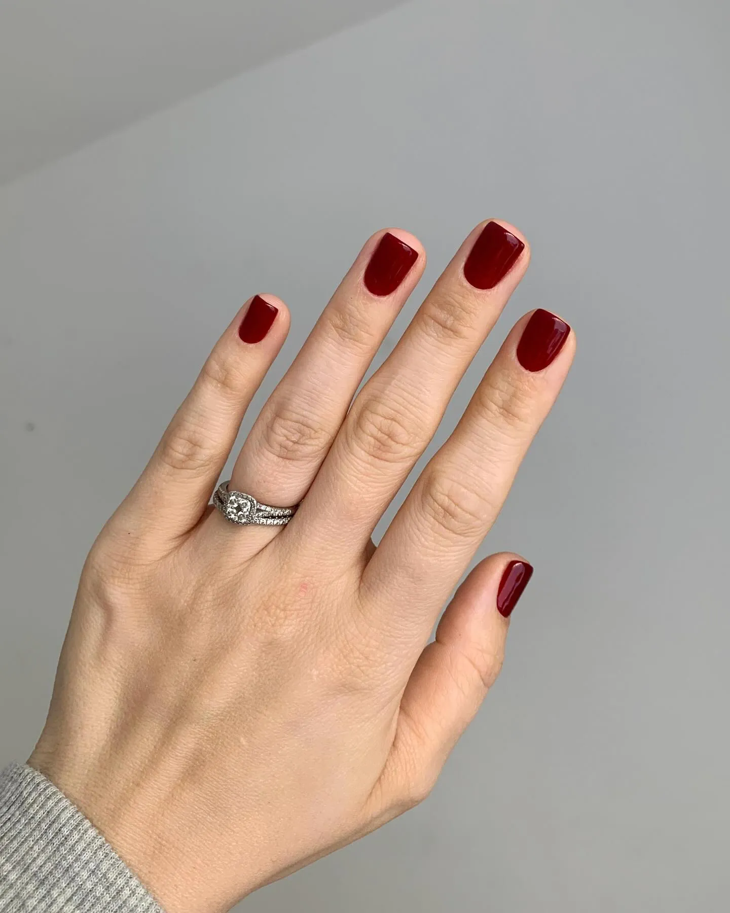 Short squared nails painted a warm wine red