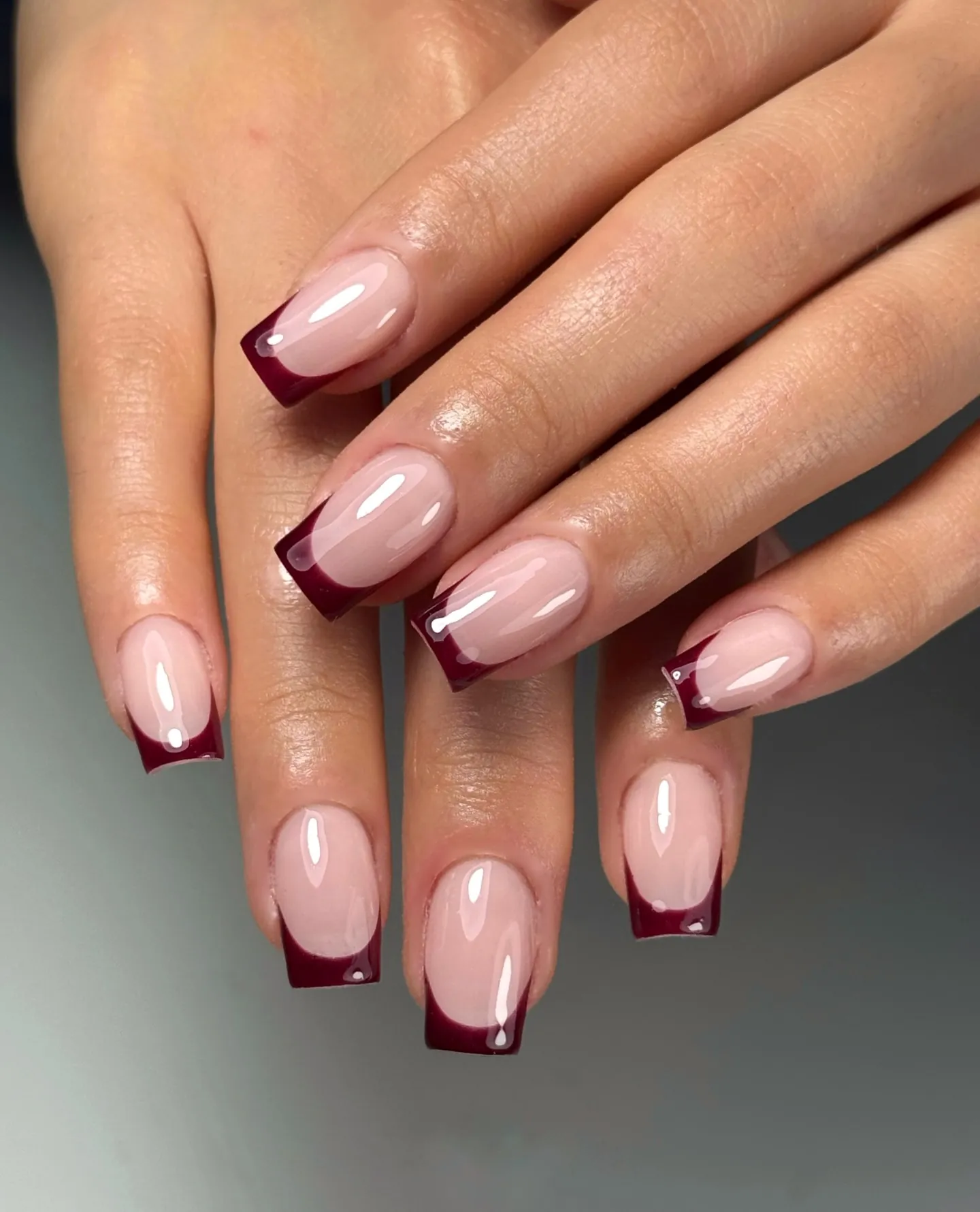 Nude pink square nails edged with narrow burgundy French tips