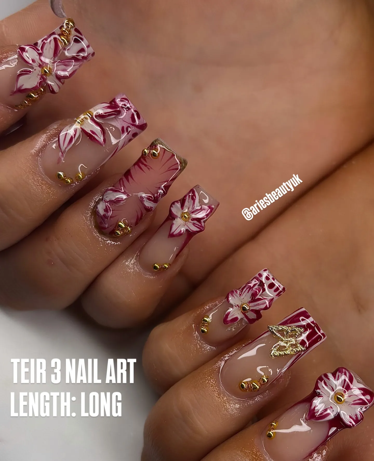Long square nails with burgundy and white raised flowers and gold details