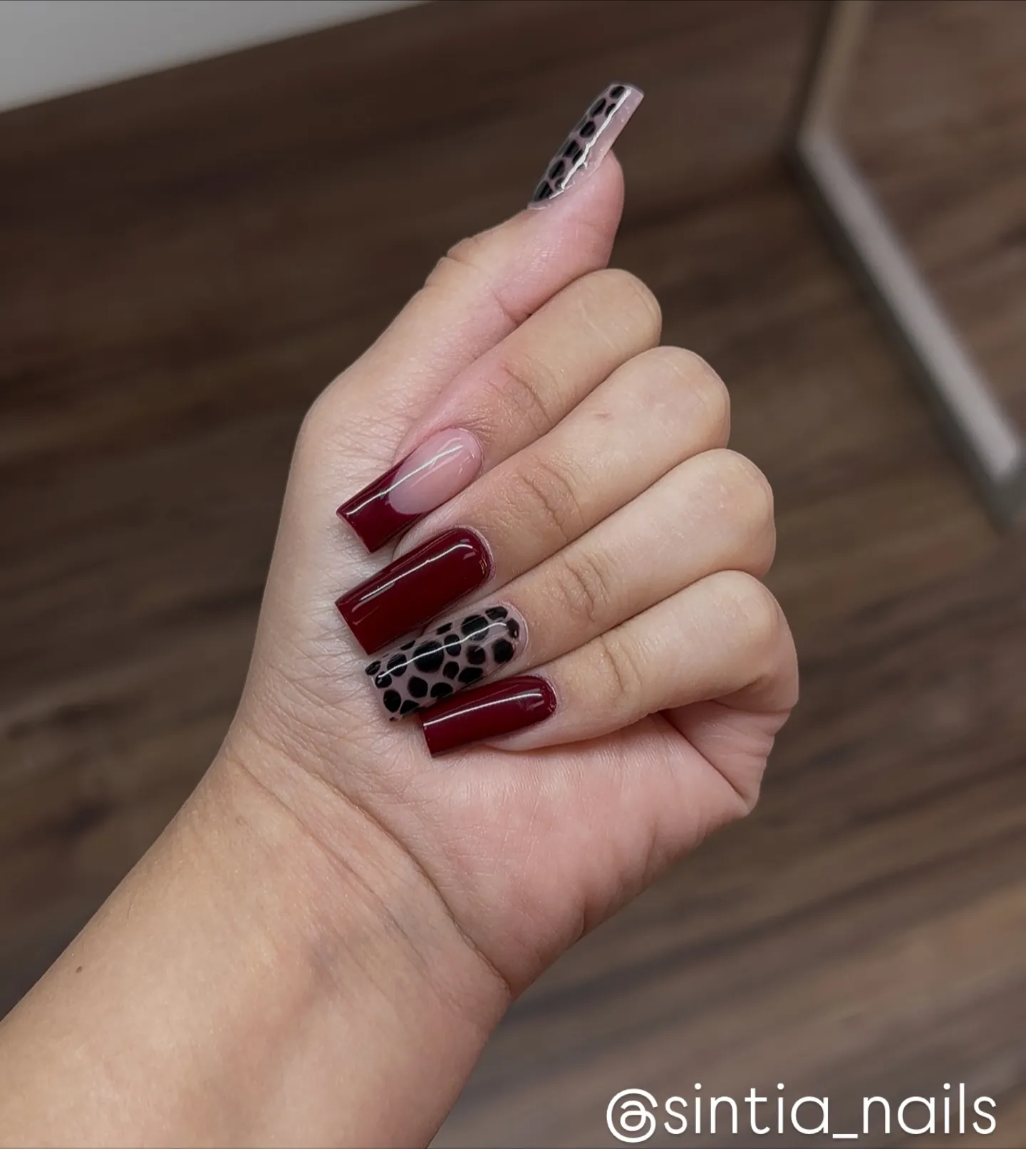 Burgundy squared nails with a dark leopard print accent