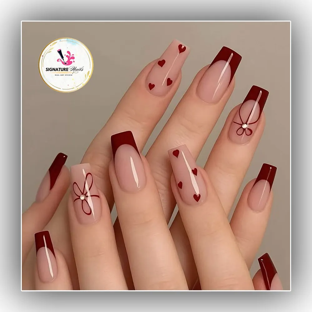 Nude square nails with burgundy French tips hearts and bow artwork