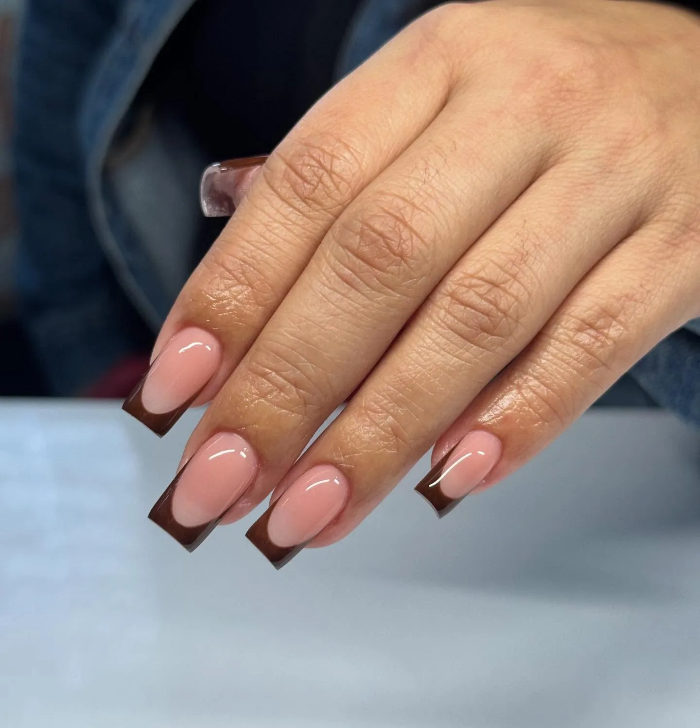 Pink square nails with straight deep brown French tips