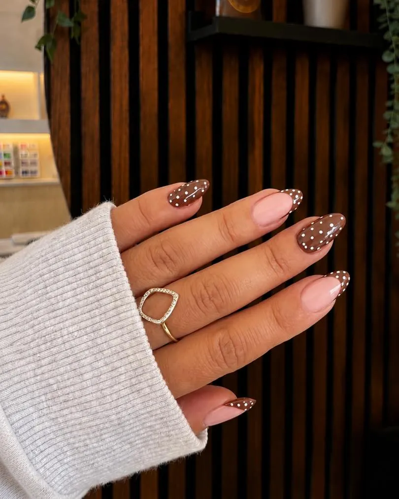Brown almond nails and pink French tips decorated with contrasting dots