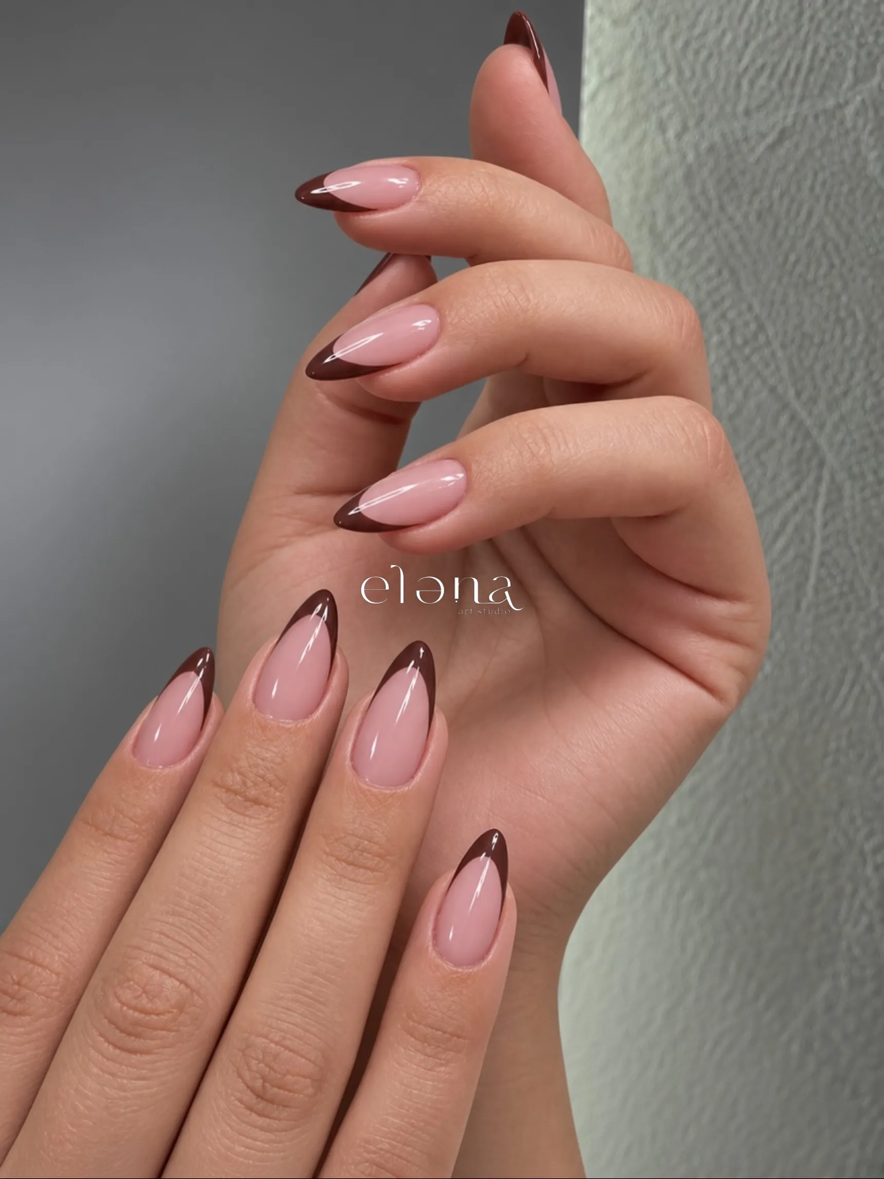 Pink pointed almond nails with sweeping asymmetric brown tips