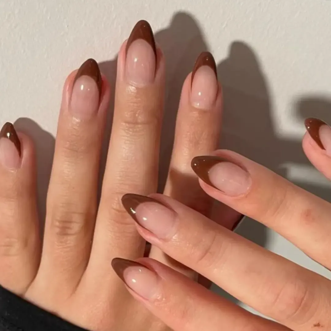 Rounded pink almond nails with broad glossy brown French tips