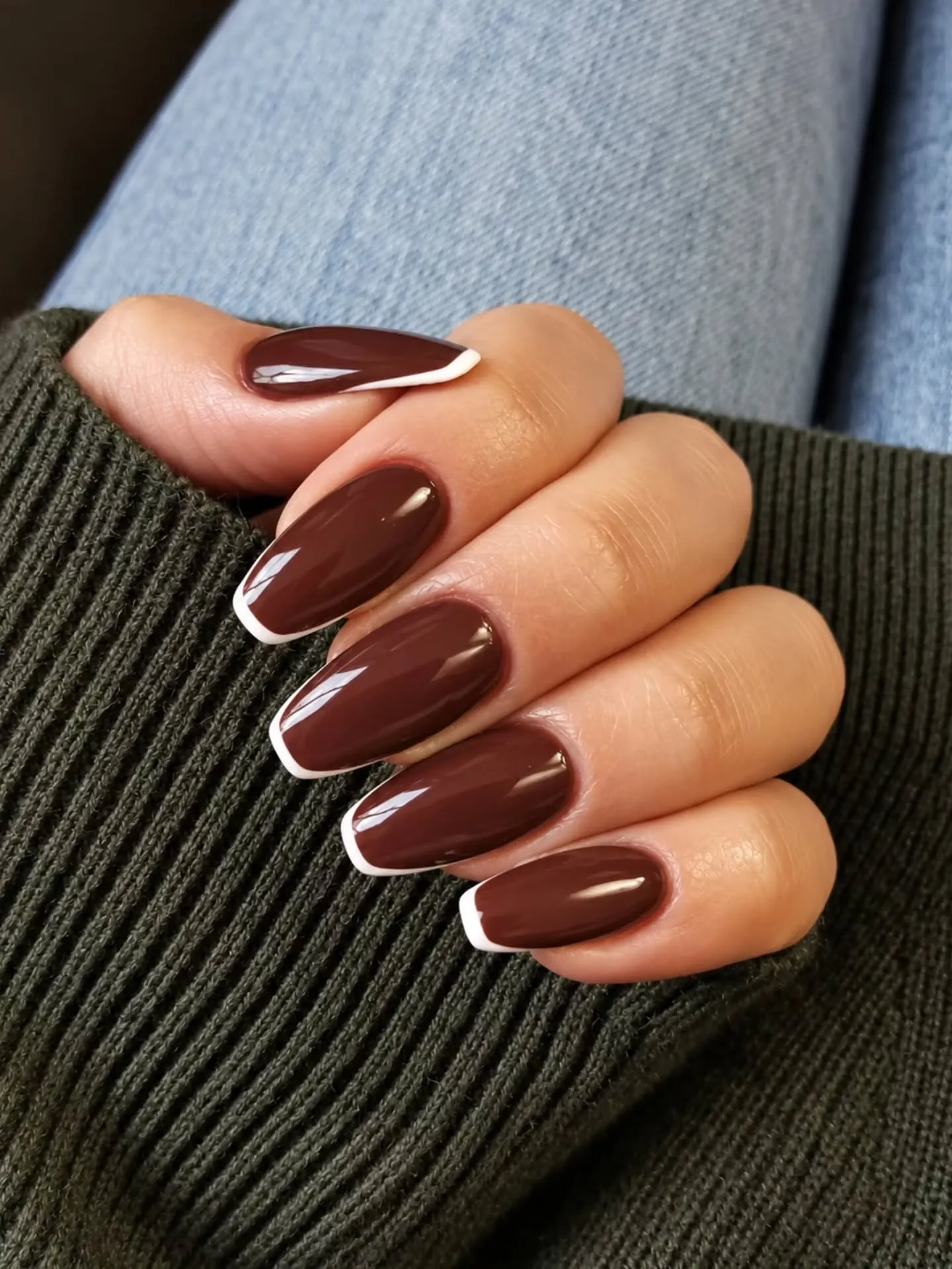Glossy brown almond nails with fine white French edges