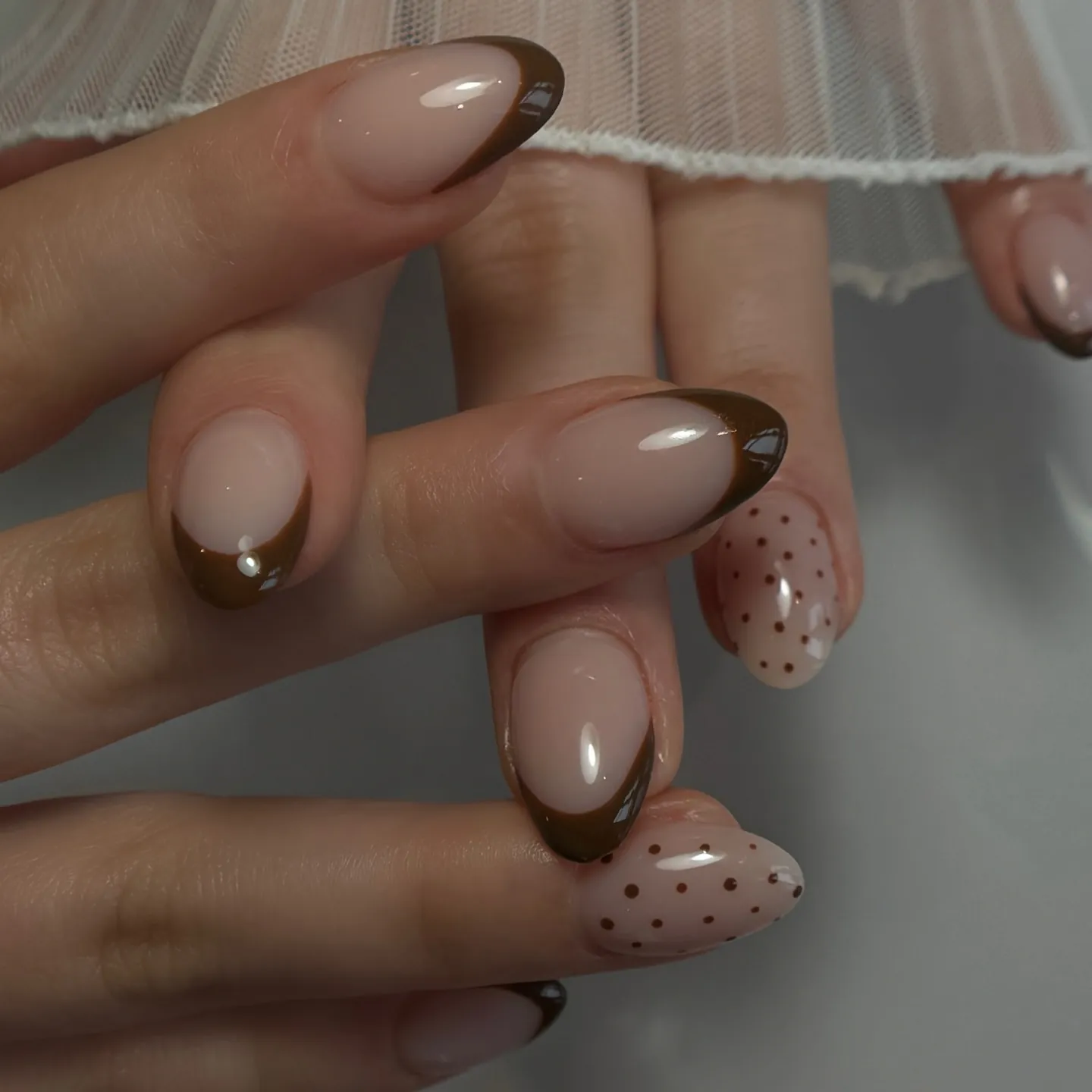 Nude oval nails with brown tips dots and small gold accents