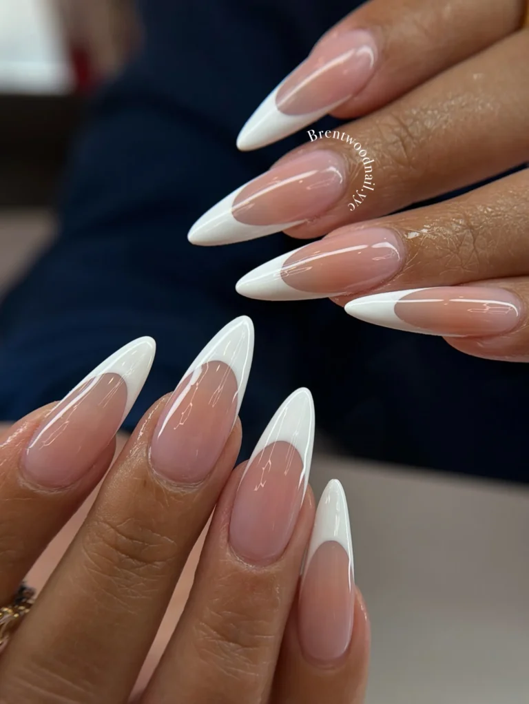 Long almond-shaped French manicure with sheer nude pink bases and crisp white tips