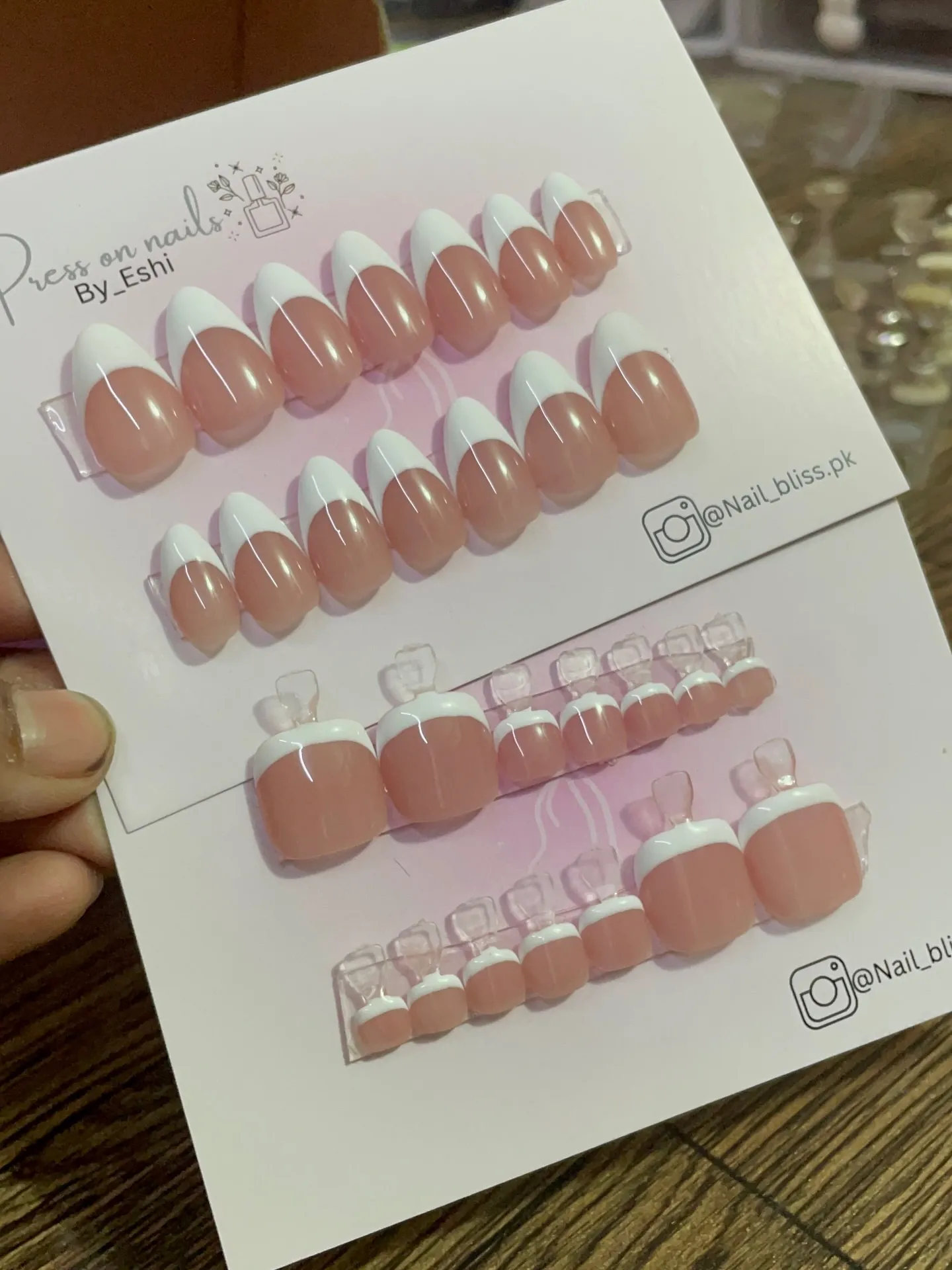 Displayed nude and white French nail sets for hands and feet